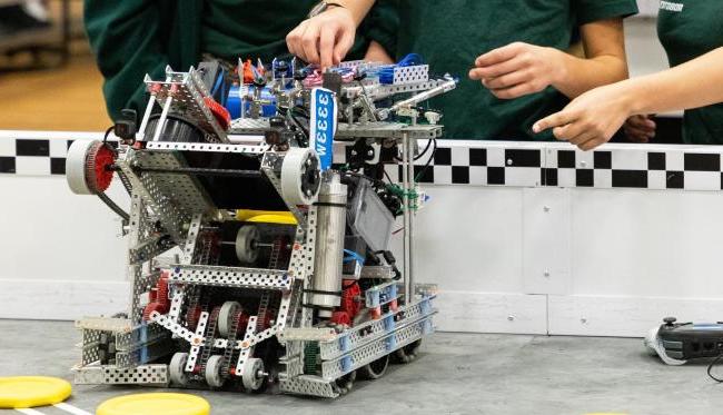 Students collaborate to fine-tune a competition robot at Kettering University's robotics event, showcasing innovative engineering and problem-solving skills.